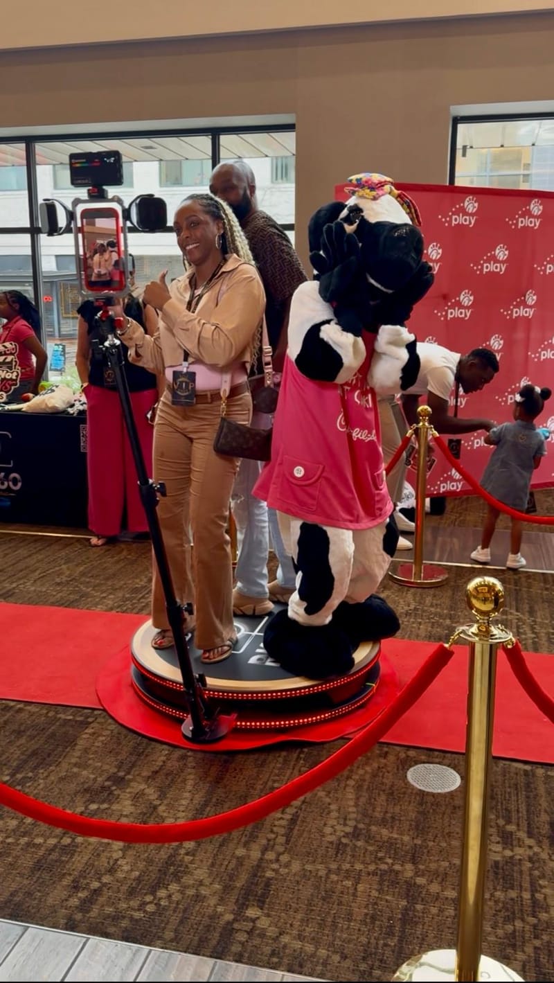 Guests using the RK360 360 Photo Booth on a red carpet platform at an Atlanta event